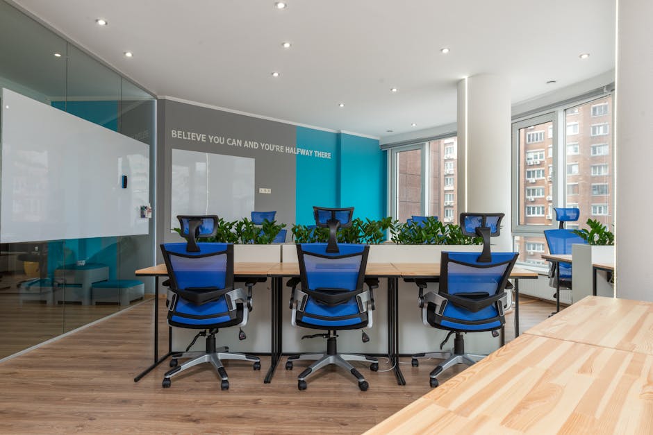 Contemporary office interior with blue chairs and greenery, promoting creativity and efficiency