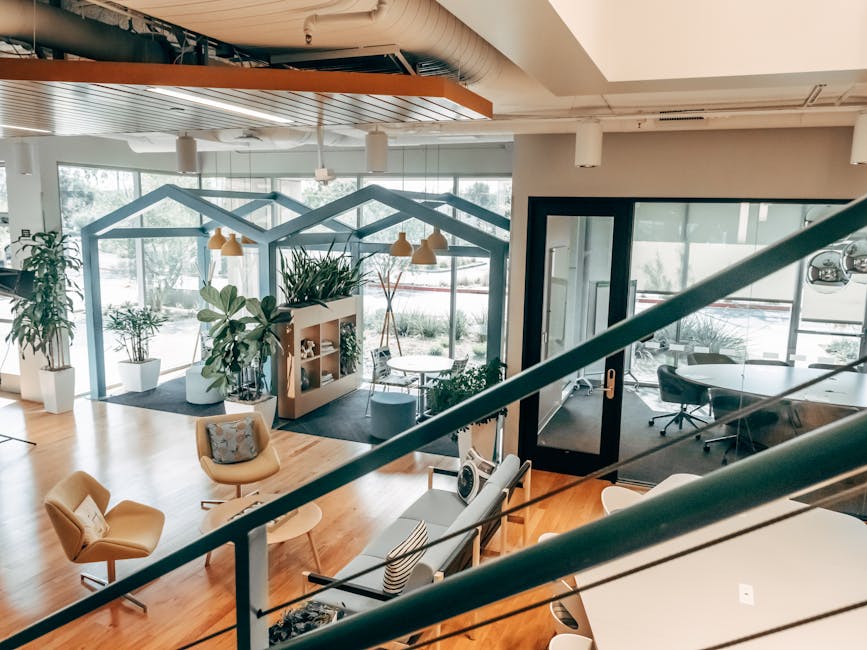 Explore a stylish open office design featuring modern furnishings, green plants, and ample natural light