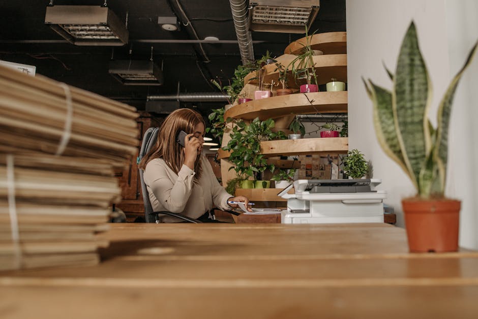 A woman making a phone call in an eco-friendly office with plants and wooden interiors